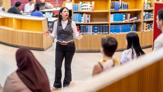 Bibliotekarie talar framför studenter 