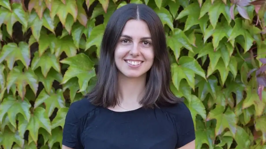 Woman in front of ivy.