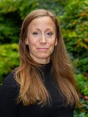Woman with long hair and a black jumper.