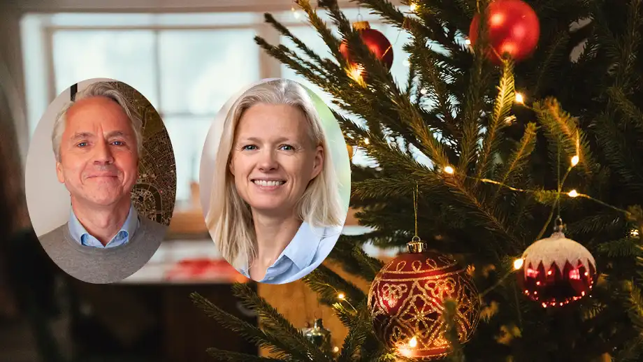 A man and a woman in front of a Christmas tree