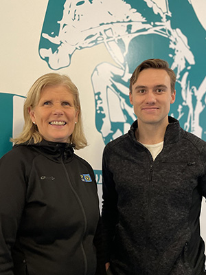 Woman and a man in fron of a painted wall