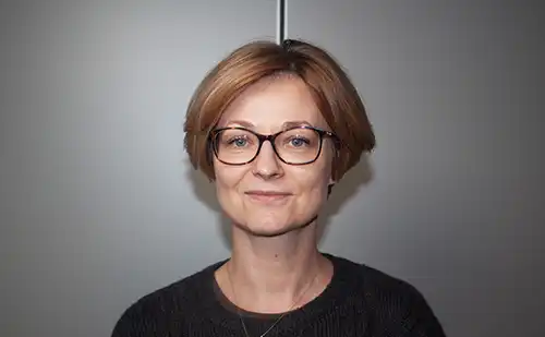 En kvinna i kort hår och glasögon