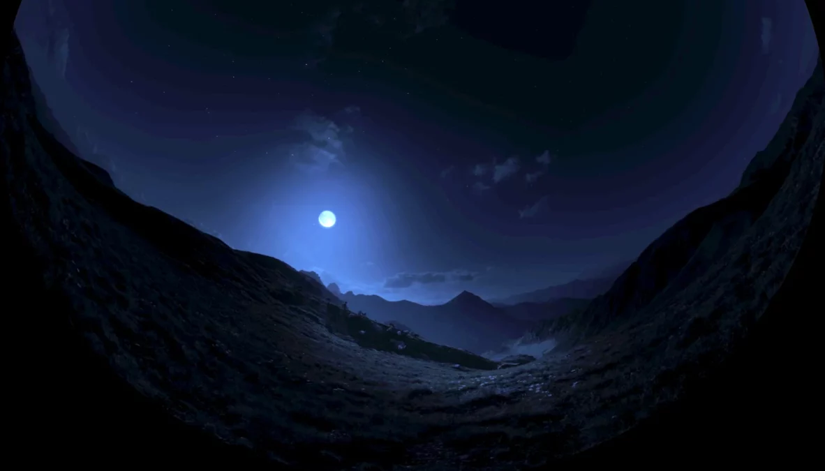 Full moon in a blue sky over montaneous terrain