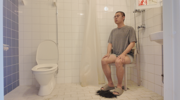 Hai Shihao sitting in the corner of a bathroom