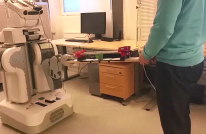 Human collaborating with robot to move a ball on a plank to a specific position. 