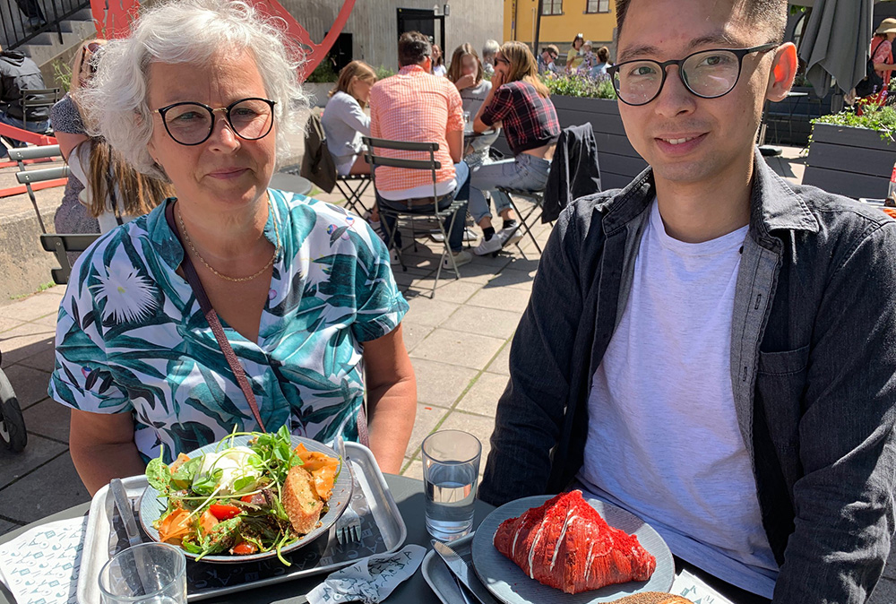 Ankie Brundin and Mo Chen eat lunch together at an outdoor café table.