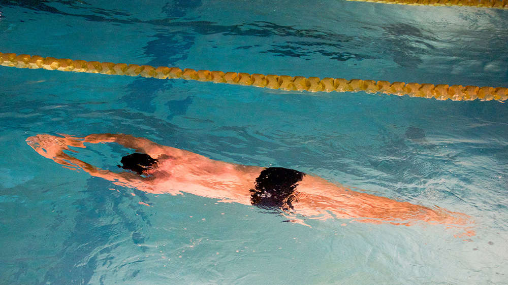 Man swimming breaststroke in a swimming pool.