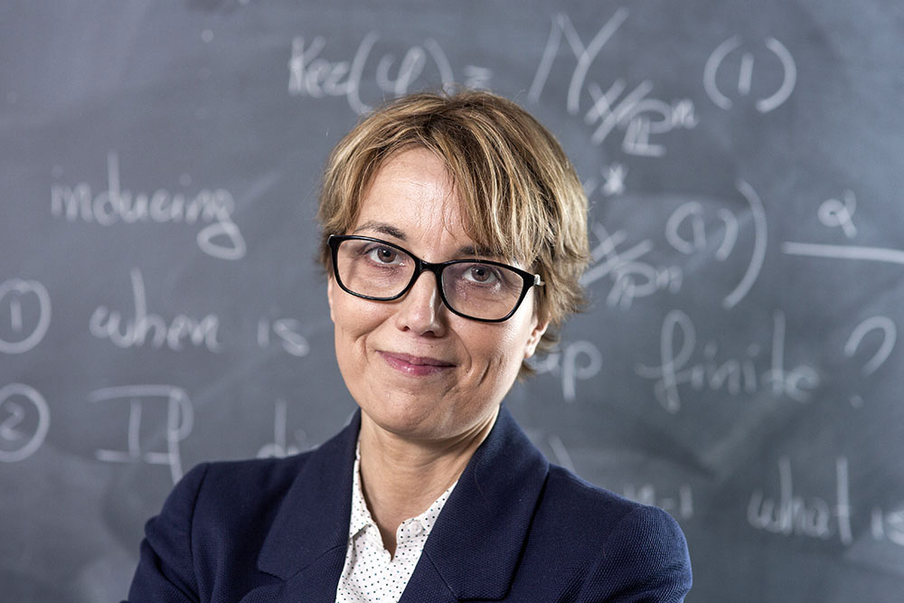 Portrait image of Sandra di Rocco in front of the blackboard.