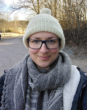 Portrait of Elina Eriksson outdoors in front of some trees and a walkway.